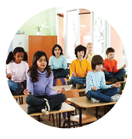 children practicing yoga seated on desks